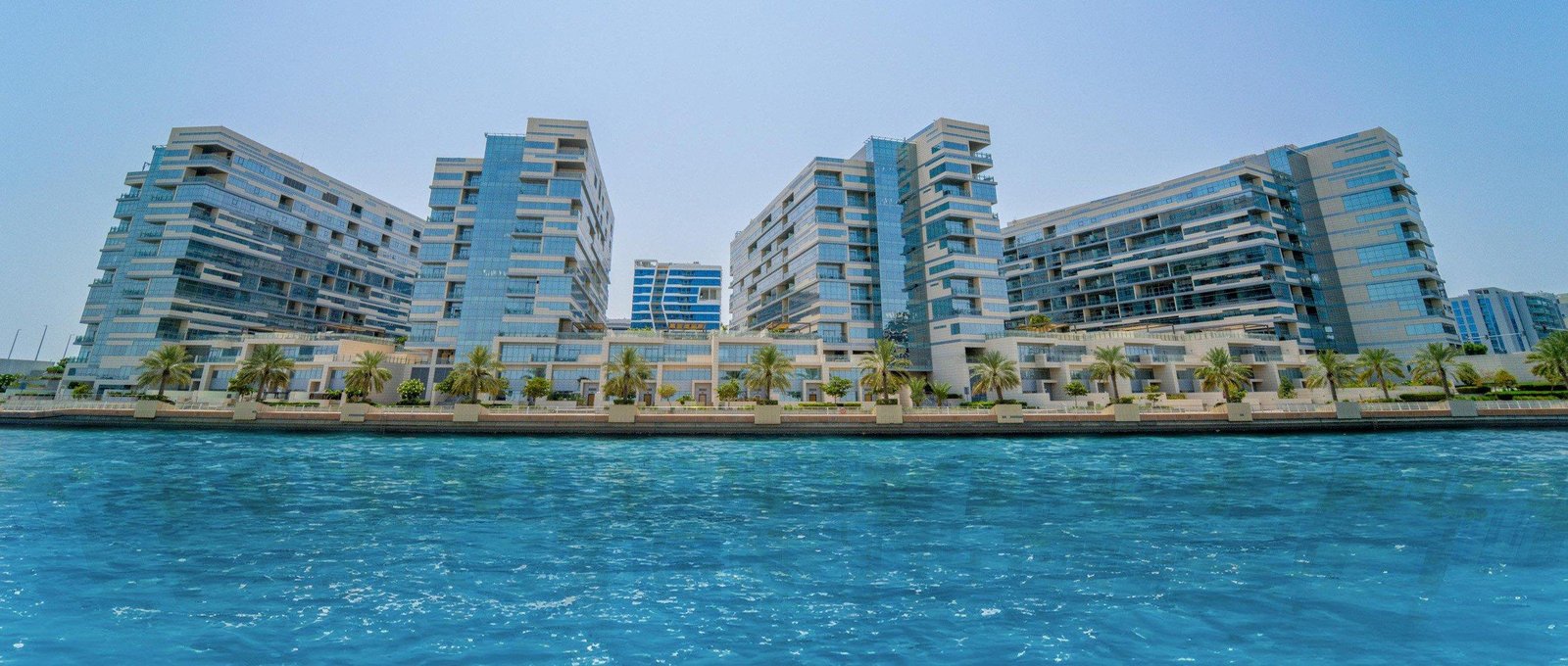 Infinity pool terrace at Luluat Al Raha Marina District framing marina and Abu Dhabi skyline views
